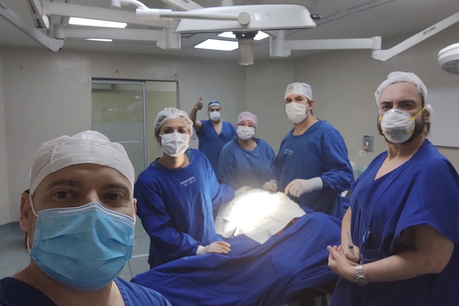 Seis integrantes del equipo alrededor de la mesa de operaciones, al terminar una cirugía.